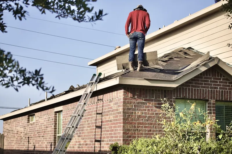 Professional roofer working on a residential roof in Clair